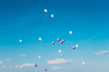 Balloons flying in the blue sky at sunny clear day