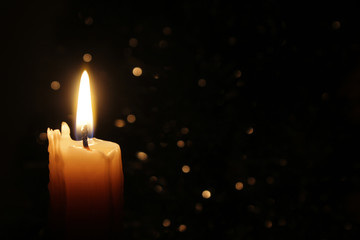 Candles Burning at Night. White Candles Burning in the Dark with focus on single candle in...