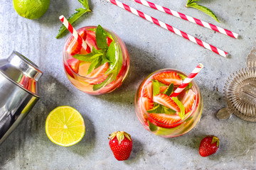 fresh lemonade with strawberries , lime and mint on a wooden background