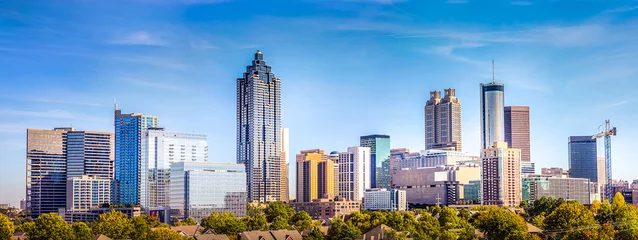 Fotobehang Verenigde Staten Downtown Atlanta Skyline met verschillende prominente gebouwen en hotels onder een blauwe hemel.