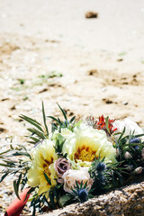 bouquet of a bride on a stone in the background of sand