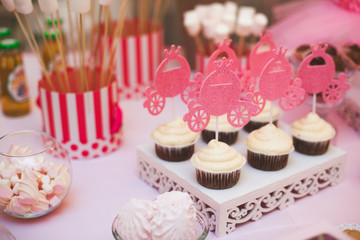 Delicious wedding candy bar or birthday party dessert table. Table with colorful sweets, candies, dessert, macaroons. Candy Bar buffet with cupcakes at restaurant.