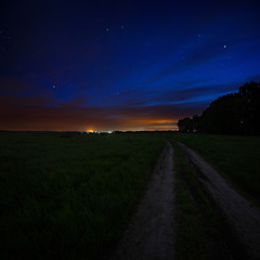 Night sky with the stars. Rural road at dusk. Cosmic space above the earth's surface. Long exposure.