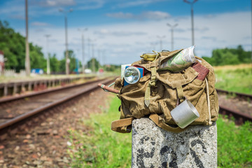 Old backpack with map and compass on train station