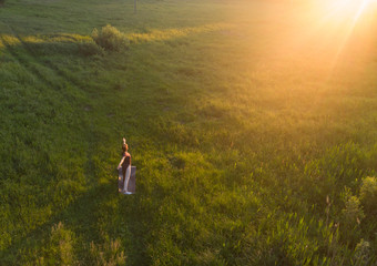 Woman practicing yoga at sunset.