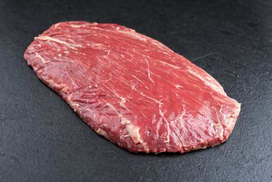 Raw dry aged wagyu flank steak as top view on a black board