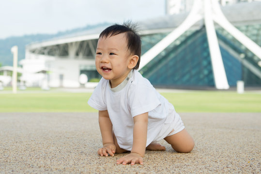 Beautiful baby boy crawling outdoor in park, learn to walk