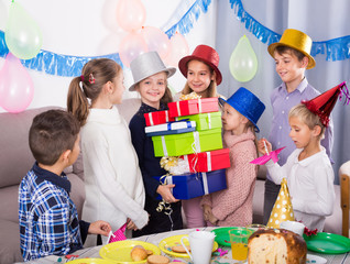 Bright children presenting gifts to girl birthday