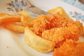 Close up of crispy chicken nuggets with French fries