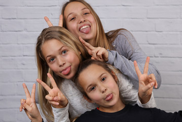Portrait of three sister girls laughing and and making funny faces. Happy kids, carefree childhood...