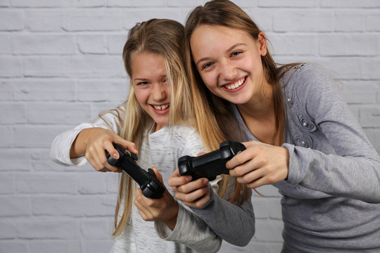 Two Sisters Kids Playing Video Games At Home Together. Happy Childeren, Carefree Childhood Concept