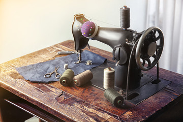 Vintage sewing machine with fabric and threads indoors