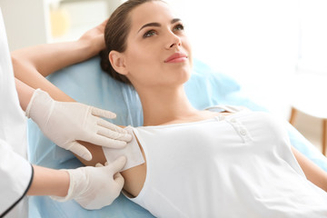 Woman getting wax epilation in salon