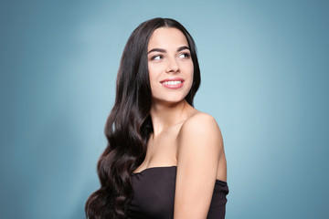 Naklejka premium Portrait of beautiful model with gorgeous curly hair on color background