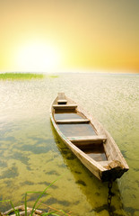 Fototapeta premium Boat at coast against asunset.