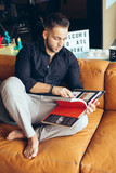 Young businessman reading book while sitting on sofa
