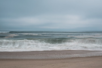Long exposure of waves crashing on to beach.