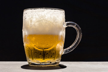 Frosty and refreshing and sparkling beer mug to black background