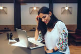 Smiling businesswoman working on laptop in office