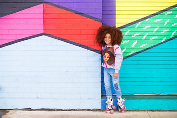 Portrait of cute girl standing against colorful background