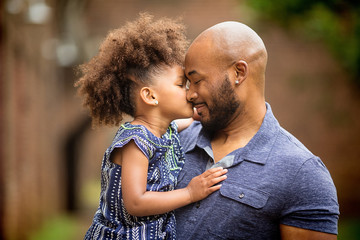 Father carrying daughter outdoors