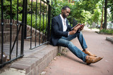 Businessman reading book while sitting outdoors
