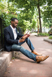 Businessman reading book while sitting outdoors