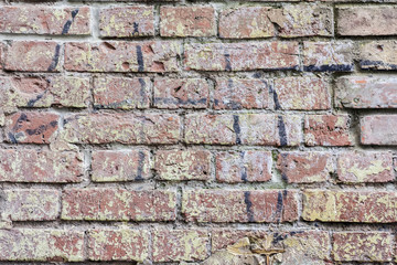 Background of old vintage dirty brick wall, surface close-up. Colorful grunge texture of wall with peeling plaster, copy space