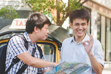 Traveller asking directions from taxi driver to get him to landmark in bangkok thailand.