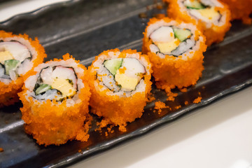 California maki sushi roll on black plate, japanese food
