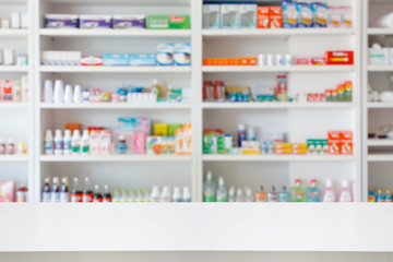 Apotheek drogisterij aanrechttafel met wazig abstracte achtergrond met medicijnen en gezondheidsproducten op planken