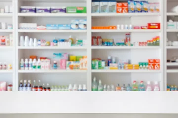 Papier Peint photo Pharmacie Table de comptoir de pharmacie avec fond abstrait flou avec médicaments et produits de santé sur les étagères