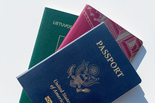 Multiple Passports - Dark Blue US Passport Alongside EU Style Red And Green Passports