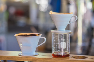 Drip brewing, filtered coffee, or pour-over is a method which involves pouring water over roasted, ground coffee beans contained in a filter, Drip or brewed coffee on paper dripping bag on a cup