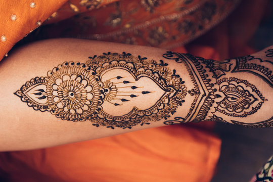 traditional Mehndi henna pattern on female leg. Close-up photo..