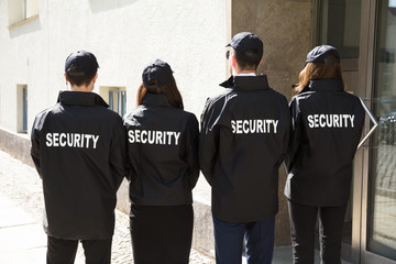 Rear View Of Security Guards Wearing Uniform