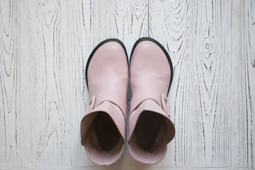 pink boots on wooden background