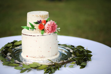 White Naked Layered Wedding Cake with Pink Peony and Roses on a Silver Platter