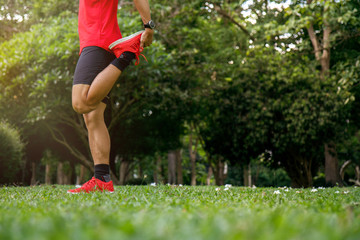 A man stretching in the park before running at the morning. Healthy lifestyle concept with copy space.