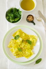 Ravioli with ricotta and spinach, served with olive oil and pine nuts. Rustic style.