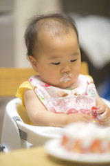 Fototapeta premium 1歳の誕生日ケーキを食べる子供