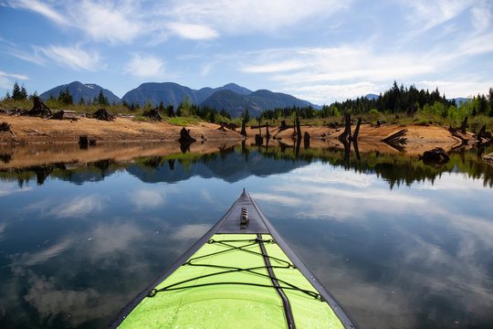 Kayaking during a beautiful morning surrounded by the Canadian Mountain Landscape. Taken in Stave Lake, East of Vancouver, British Columbia, Canada.