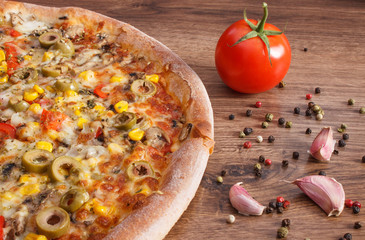 Vegetarian pizza and ingredients with spices on rustic board