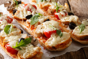 Homemade sandwich pizza baguette baked with chicken, cheese, tomatoes, olives and mushrooms...