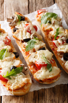 Open hot saddle baguette casserole pizza with chicken, cheese, tomatoes, olives and mushrooms. vertical