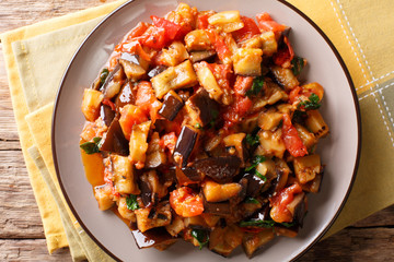 Moroccan salad from aubergines, tomatoes and garlic with spices close-up on a plate. horizontal top view
