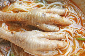Chicken feet in  spicy curry sauce with rice noodles thai food top view background