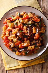Moroccan salad from aubergines, tomatoes and garlic with spices close-up on a plate. Vertical top view