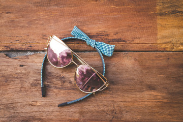 Summer accessories on wooden floor. Top view and copy space, picturesque, glasses and headband. Mock up and fashion and beauty.