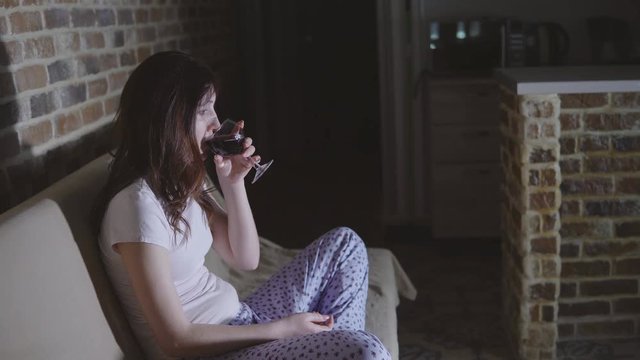 Young Woman Crying In Front Of TV And Drinking Wine.